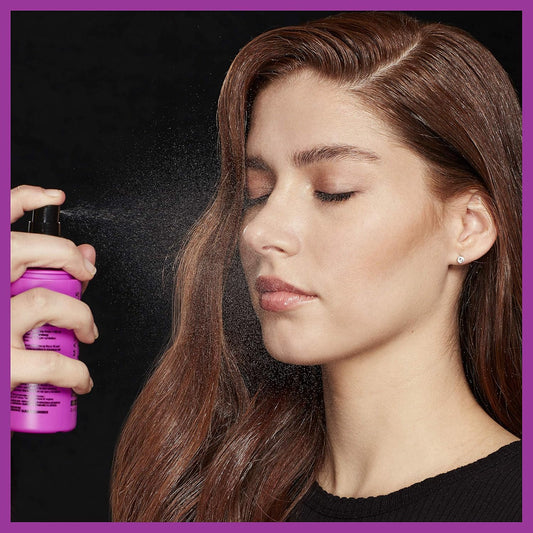 A model applying the fine mist of the Maybelline setting spray to her face to lock in her completed makeup look - Khayest