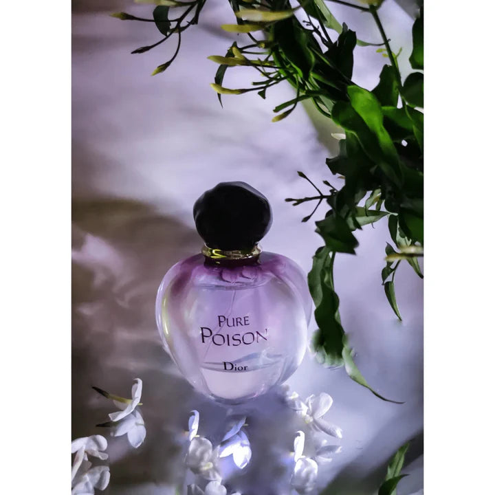 An atmospheric shot of the Dior Pure Poison perfume bottle surrounded by white jasmine flowers, representing its floral notes.