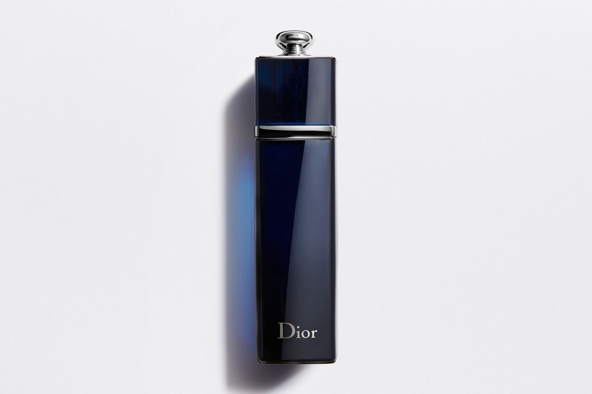 Sleek navy blue Dior Addict EDP perfume bottle with silver cap against white background, premium Dior perfume for women.