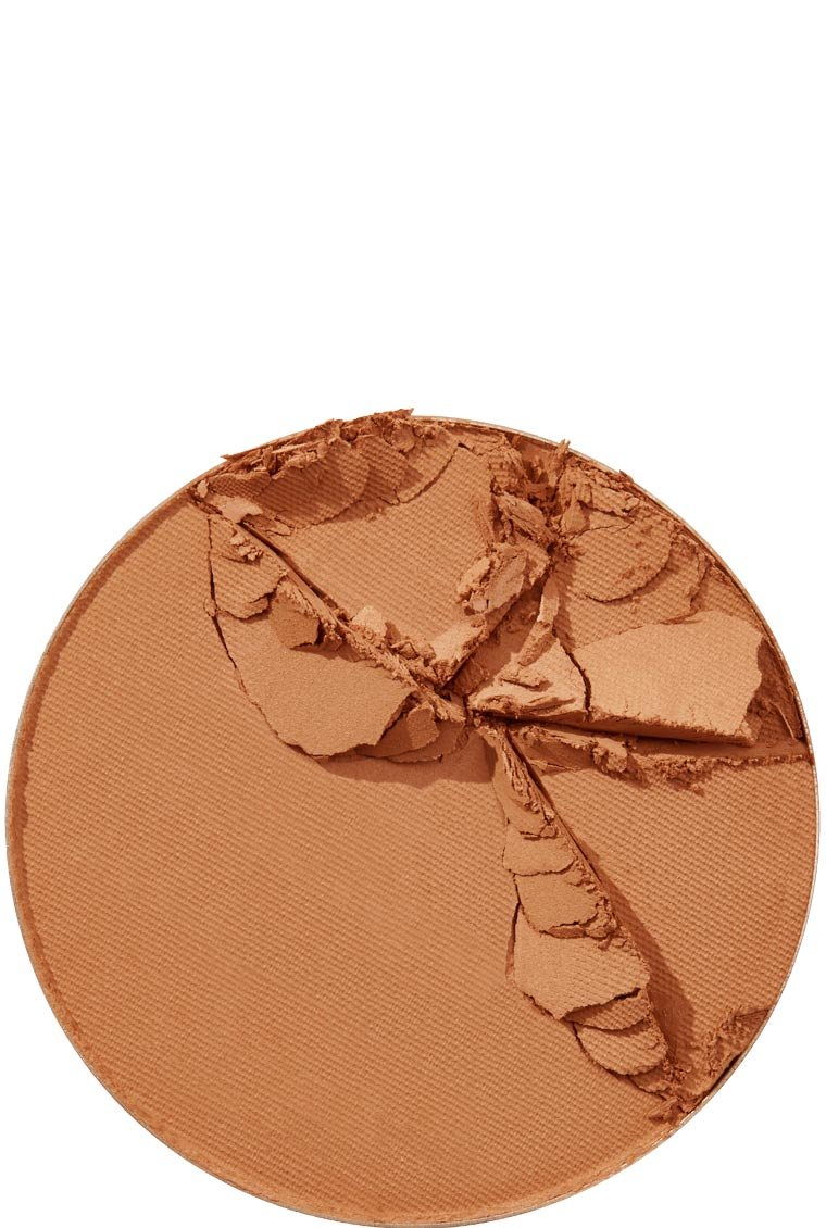 A close-up of a broken Maybelline Foundation Super Stay powder in a rich, dark tan shade, showing its texture.