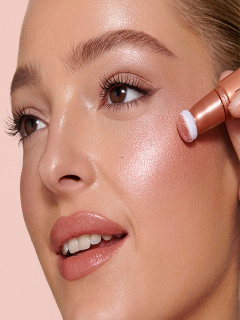 woman-close-up-face-holding-Charlotte-Tilbury-Beauty-Light-Wand-Peachgasm-Highlighter-Blush