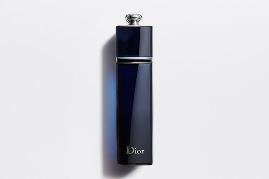 Sleek navy blue Dior Addict EDP perfume bottle with silver cap against white background, premium Dior perfume for women.