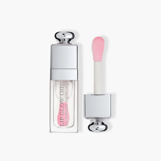 Dior Lip Glow Oil in delicate light pink shade with signature silver cap and specialized soft-tip applicator for precise application