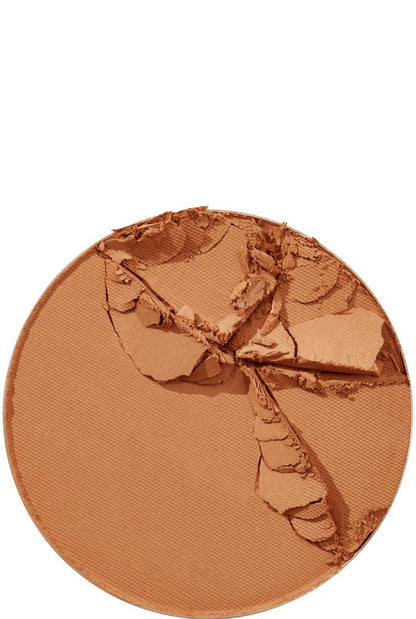A close-up of a broken Maybelline Foundation Super Stay powder in a rich, dark tan shade, showing its texture.