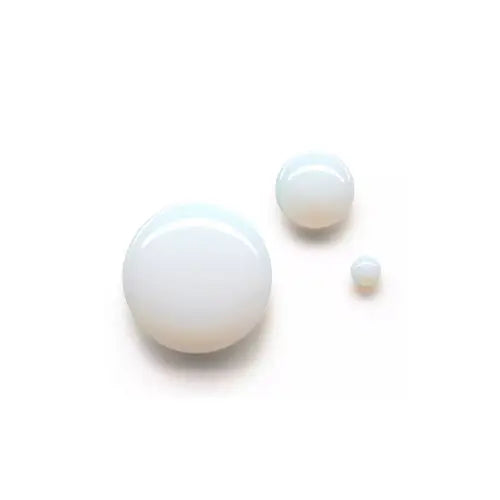 Three white pearls of different sizes on a light beige background